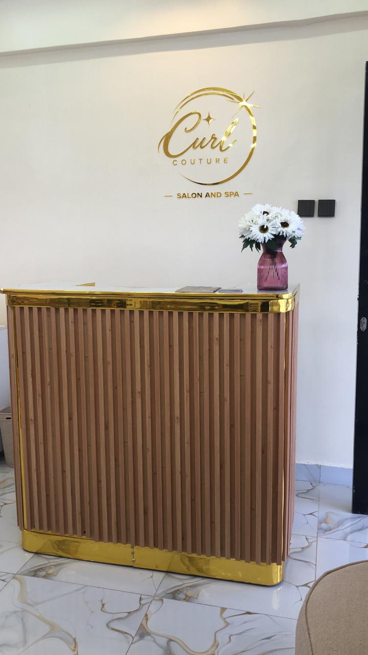 Curl Couture reception desk and visible salon logo wall